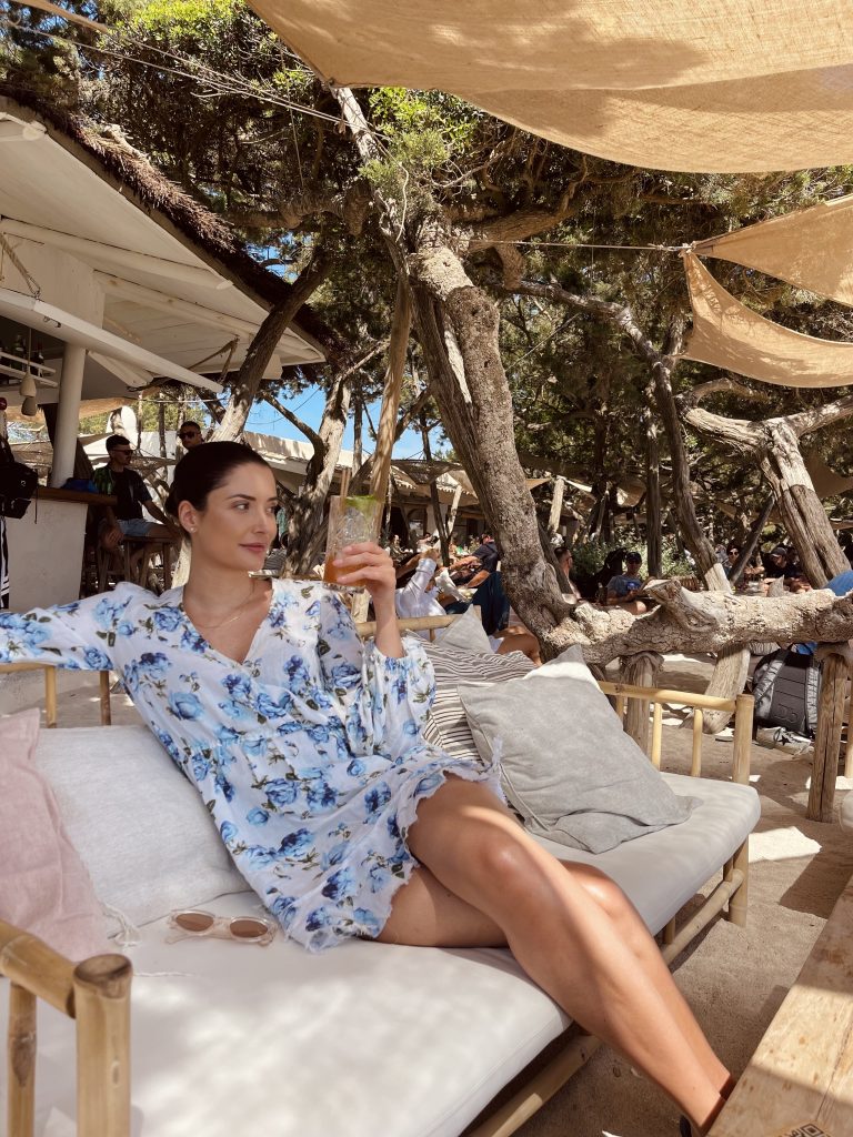 Lifestyle expert Alina Barchet is sitting at Casa Jondal beach club in Ibiza. Wearing a dress from the Kooples.