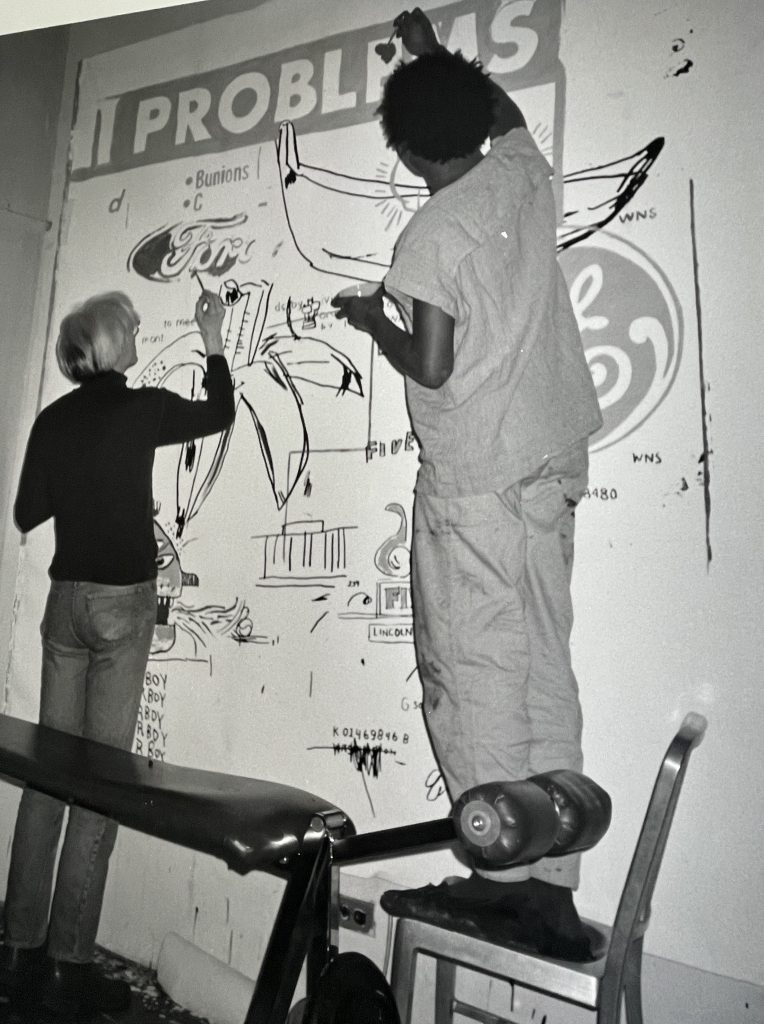 Andy Warhol and Jean Michel Basquiat working on a canvas at Andy Warhols Studio.