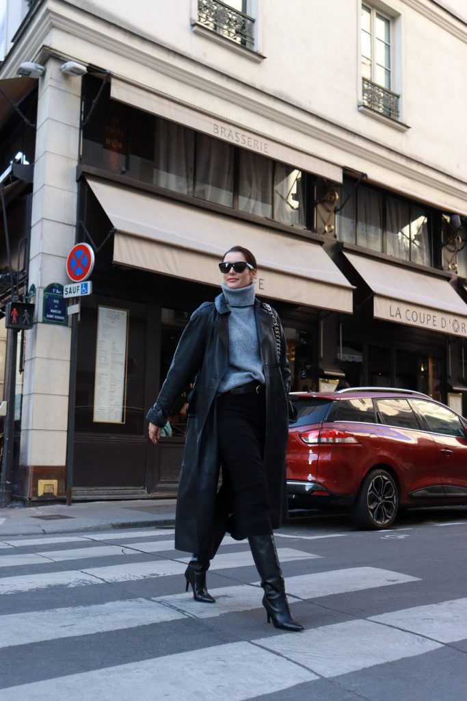 Fashion blogger and fashion expert Alina Barchet is wearing a long, black leather coat, a grey turtle neck pullover, a black pencil skirt and heeled black leather boots during a street style shoot in Paris.