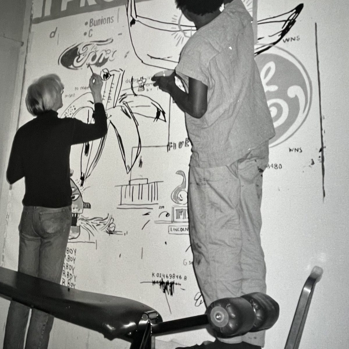 Andy Warhol and Jean Michel Basquiat Andy Warhol and Jean Michel Basquiat working on a canvas at Andy Warhols Studio.